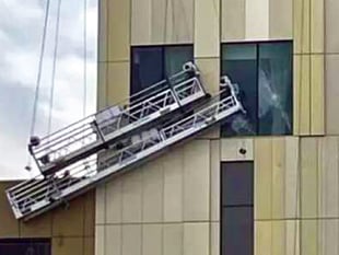 Storm winds batter workmen’s cradles into side of new hotel