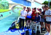 Students help create vibrant mural at station