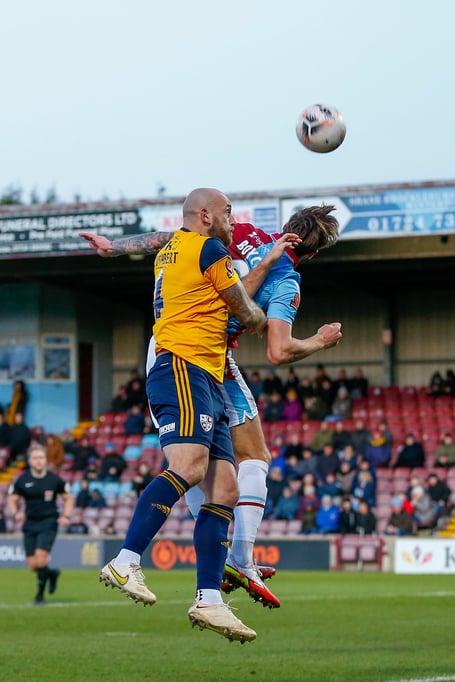 Scott Cuthbert battles for Woking.