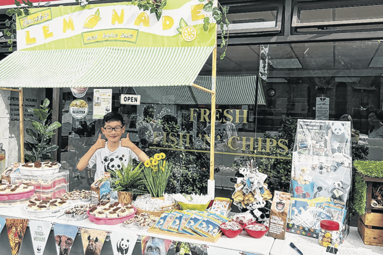 Enthusiastic fundraiser Jacob Tang with an impressive selection of wares on his stall in Knaphill