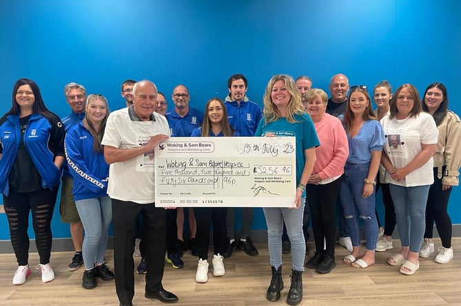 Tony Bristow, widower of Maz Bristow, presents the cheque for £5,256.96 to the hospice’s Sam Jones, watched by members of Sheerwater FC and the Bristow family