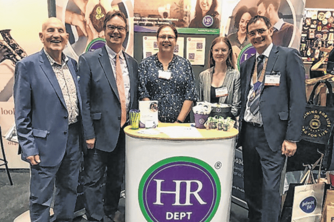 Jonathan Lord, second left, enjoying the Woking Means Business exhibition with a local HR company and with Dave Peet and Paul Webster of Woking Chamber of Commerce