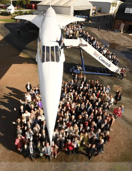 Some of the former Concorde staff underneath the nose of the plane which is part of the Brooklands collection
