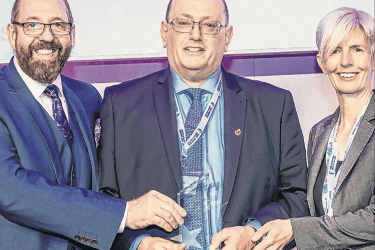 Steve Head, centre, accepts his award for helping transform women’s lives