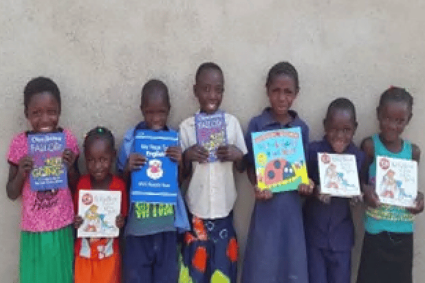 Children show off books borrowed from their new school library