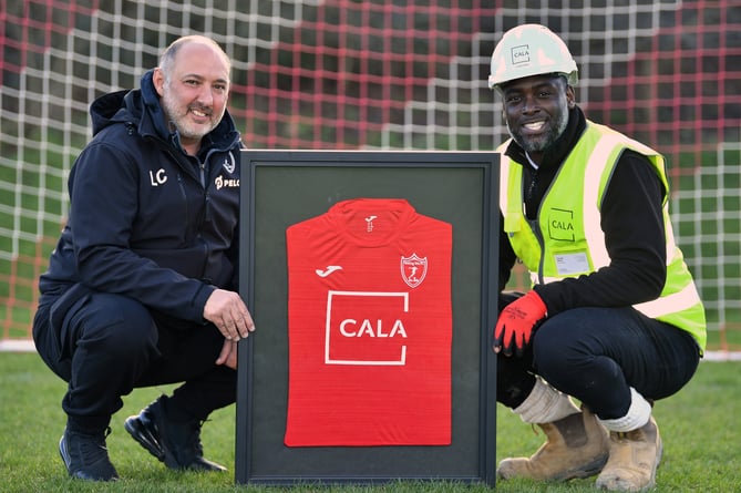 Woking Vets FC founder and chairman Lee Cooke handing over a framed kit to Cala site manager Tyrone Henry