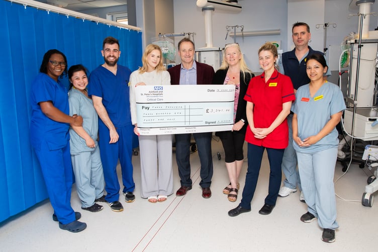Cassie and her family present a cheque to the ICU team