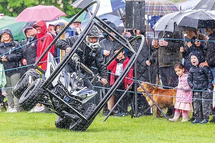 Carnival-goers, dressed to defy the constant rain, were amazed by a Stannage Stunt Team rider performing at this year’s Chobham Carnival