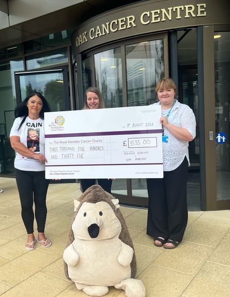 Cain Critcher's mum's cousins Joanne Brazil, left, and Kim Marlow hand over the cheque to the Royal Marsden Hospital