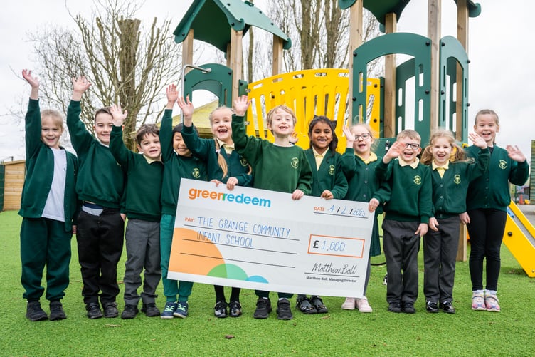 Children from The Grange Community Infant School’s Eco Team pose with the cheque for £1,000 that they won as part of Surrey’s Rethink Waste scheme.