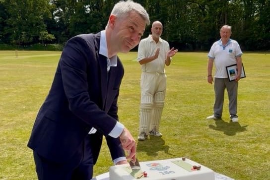Woking MP Will Forster cuts the celebration cake