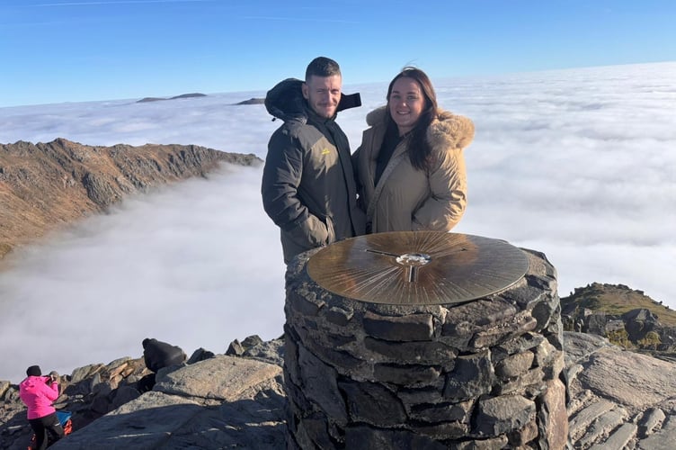 Jess Gibelli at the summit of Snowdon. // A young woman's stomach bug and bloating turned out to be a rare and aggressive form of blood cancer. Jess Gibelli, 28, started experiencing nausea, sickness, severe fatigue and bloating in November 2025 but she initially put it down to a sickness bug. She was working two physically demanding jobs as a florist and running her own event décor business - Viva La Fiesta - and she'd go straight to bed after work without having any dinner. But when her heart rate suddenly shot up to 160 while lying down in December 2025, Jess was rushed to hospital and doctors found a 30cm abdominal mass on an ultrasound.