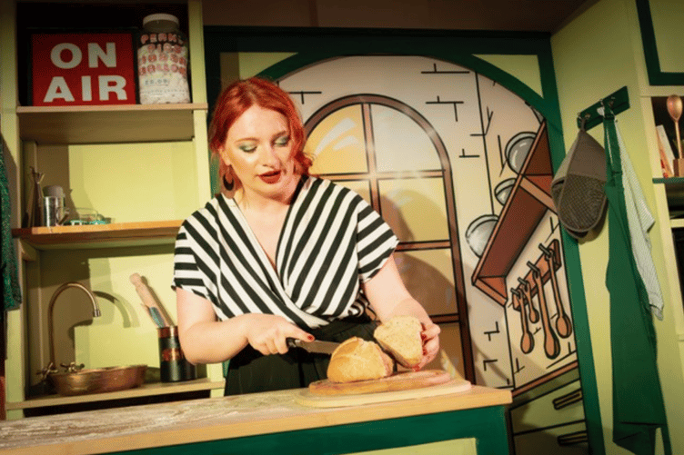 Ellen Carnazza cuts bread as Petronella Parfait in Crumbs, Woking Library, June 19th 2026.