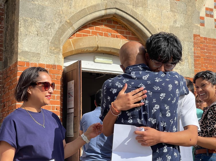 He's done it! Kushal Karanjeet hugs his father as he reads of his clutch of 9s and 8s in his GCSEs