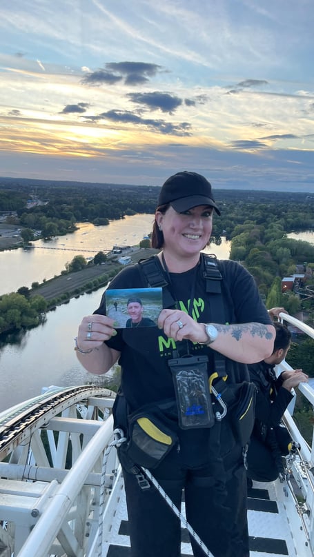 Ness Hale holds a photograph of her son Luke at the top of Hyperia as the sun sets following her 236ft climb in his memory.