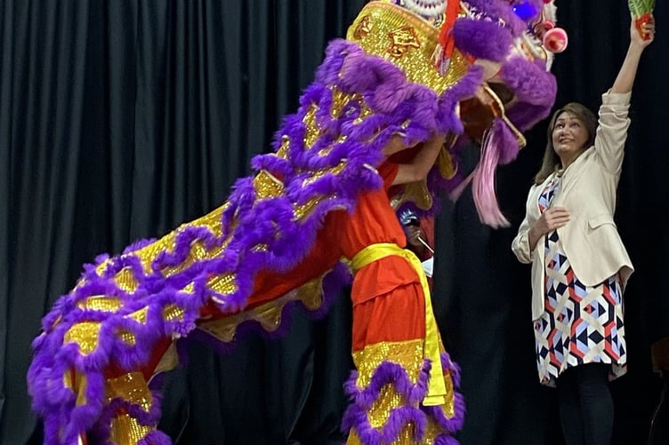 The lion dancer 'eats the greens' as a symbol of prosperity